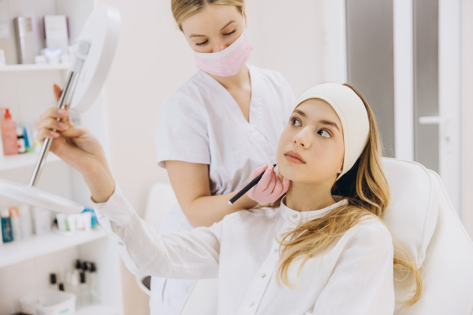 Cosmetologist marking facial injection sites for botox procedure in professional aesthetic medical